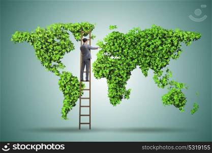 Businessman on ladder in green environment concept