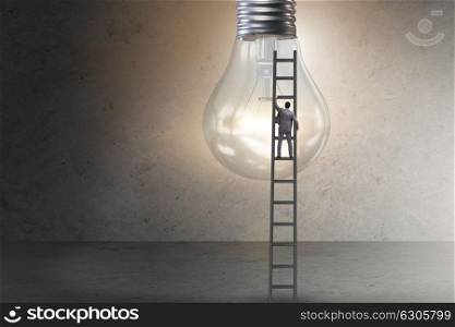 Businessman on ladder with light bulb