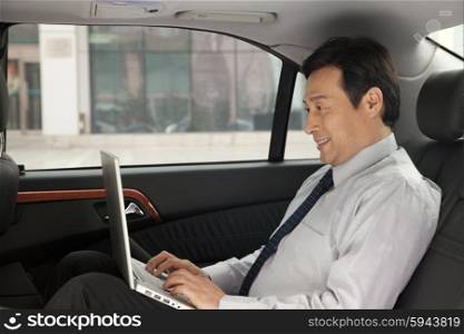 Businessman on laptop in car