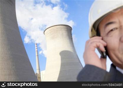 Businessman on mobile phone at power plant