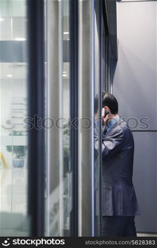 Businessman on the phone, glass wall