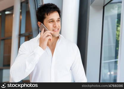 Businessman on the phone sitting at the computer in his office. Being connected and in touch