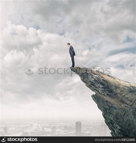 Businessman on top. Businessman standing on edge of hill and looking down