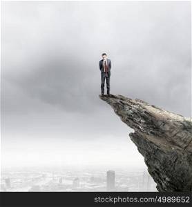 Businessman on top. Businessman standing on edge of hill and looking down
