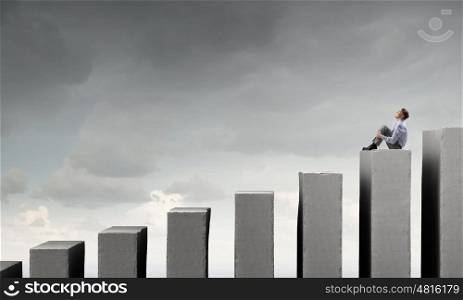 Businessman on top of graph . Smiling businessman sitting on top of graph bar