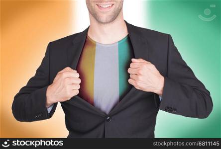 Businessman opening suit to reveal shirt with flag, Ivory Coast