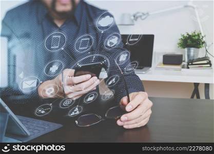 businessman or designer using smart phone and laptopcomputer and holding eyeglasses in modern office,virtual graphic icon diagram