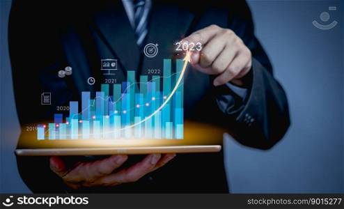 Businessman or trader is use tablet with growing virtual hologram stock graph, business financial data investment.planning and strategy, Stock market, Business growth 2023 concept.