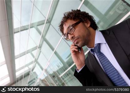 Businessman outside office making phone cal