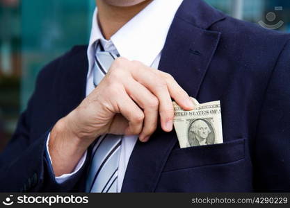 businessman outside office taking banknotes