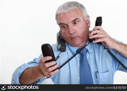 businessman overwhelmed with phone calls