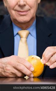 Businessman peeling an orange