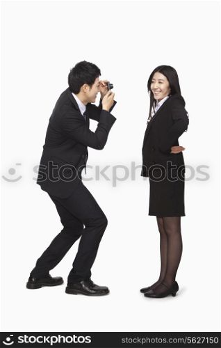 Businessman photographing businesswoman