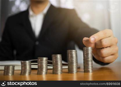 Businessman picks coins on the table, counts money . Business concept.