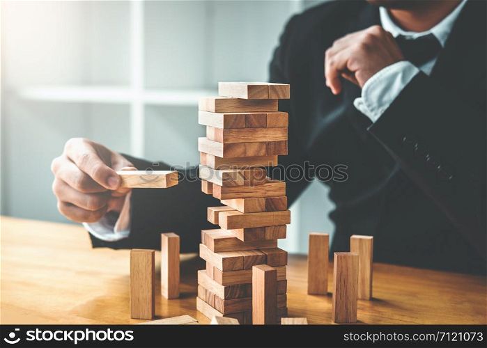 Businessman plan and strategy in business Domino Effect Leadership Management Solution concept