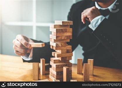 Businessman plan and strategy in business Domino Effect Leadership Management Solution concept