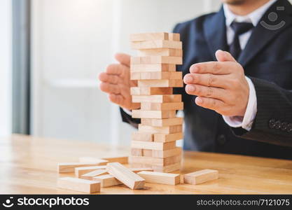 Businessman plan and strategy in business Domino Effect Leadership Management Solution concept