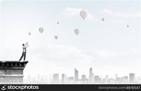 Businessman play pipe. Young businessman on building top playing pipe