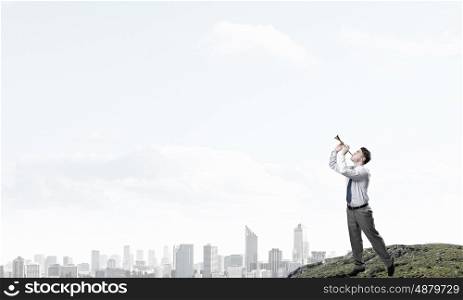 Businessman play pipe. Young businessman on hill top playing pipe