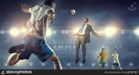 Businessman playing ball. Young businessman in suit playing football with team at stadium