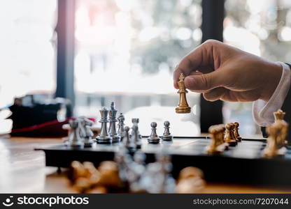 Businessman playing chess game beat opponent with strategy concept.