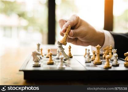 Businessman playing chess game beat opponent with strategy concept.