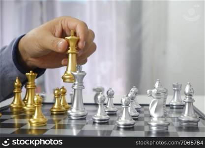 Businessman playing chess game; business strategy, leadership and management concept.