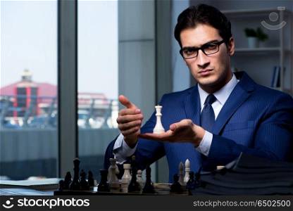 Businessman playing chess in strategy concept