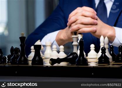 Businessman playing chess in strategy concept