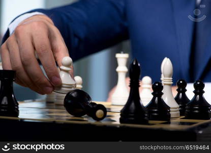 Businessman playing chess in strategy concept