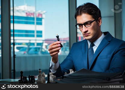 Businessman playing chess in strategy concept