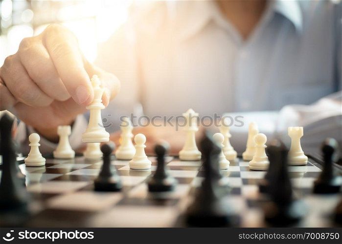 businessman playing chess on board in office  strategy and competition concept.