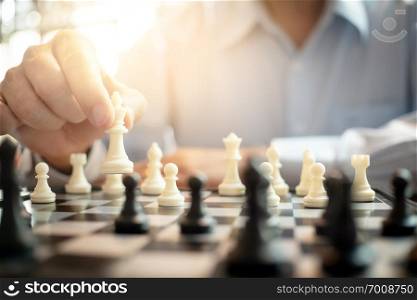 businessman playing chess on board in office  strategy and competition concept.
