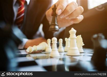 businessman playing chess on board in office, strategy and competition concept