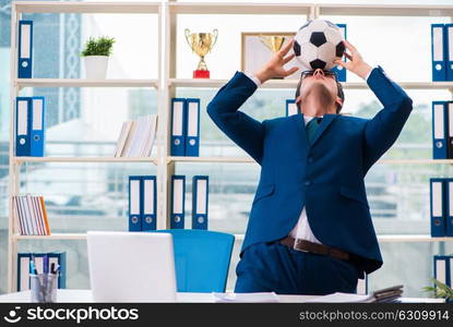 Businessman playing football in the office