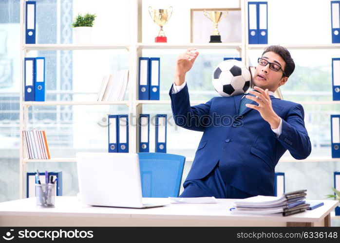 Businessman playing football in the office