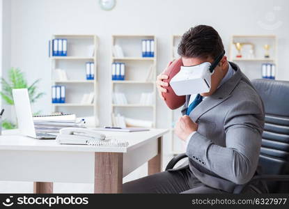 Businessman playing virtual reality football in office with VR goggle. Businessman playing virtual reality football in office with VR g