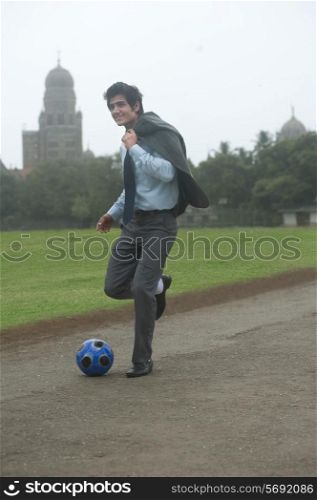 Businessman playing with a football