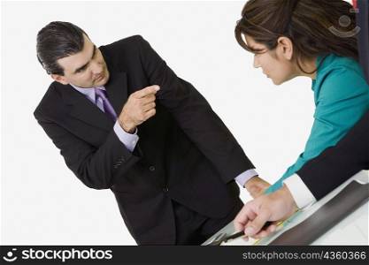Businessman pointing at a businesswoman sitting in front of him
