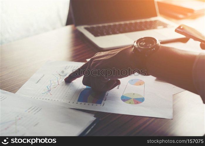 Businessman pointing finger analyzing statistics financial graph.. Businessman pointing finger analyzing statistics financial graph