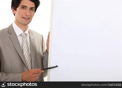 Businessman pointing to a blank flip chart