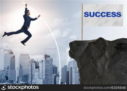 Businessman pole vaulting towards his success goal