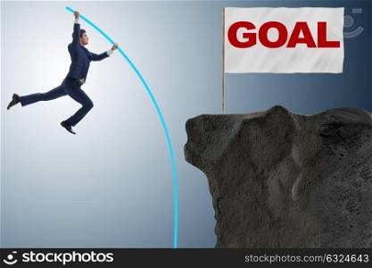 Businessman pole vaulting towards his success goal