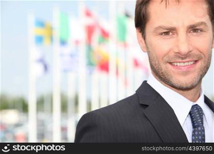businessman posing in front flags