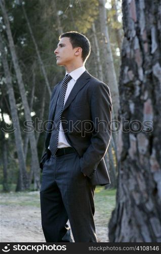 Businessman posing relaxed on a park forest outdoor landscape