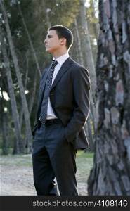 Businessman posing relaxed on a park forest outdoor landscape