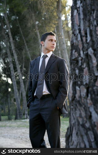 Businessman posing relaxed on a park forest outdoor landscape