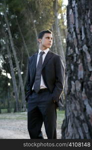 Businessman posing relaxed on a park forest outdoor landscape