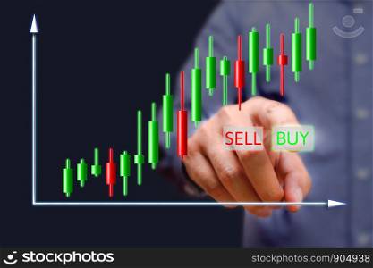 Businessman press buy button on screen with stock charts.