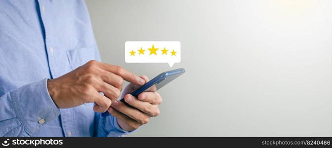 Businessman press close-up button on smartphone screen with golden light star icon and cool star gradation to get best score. Can be used in technology business